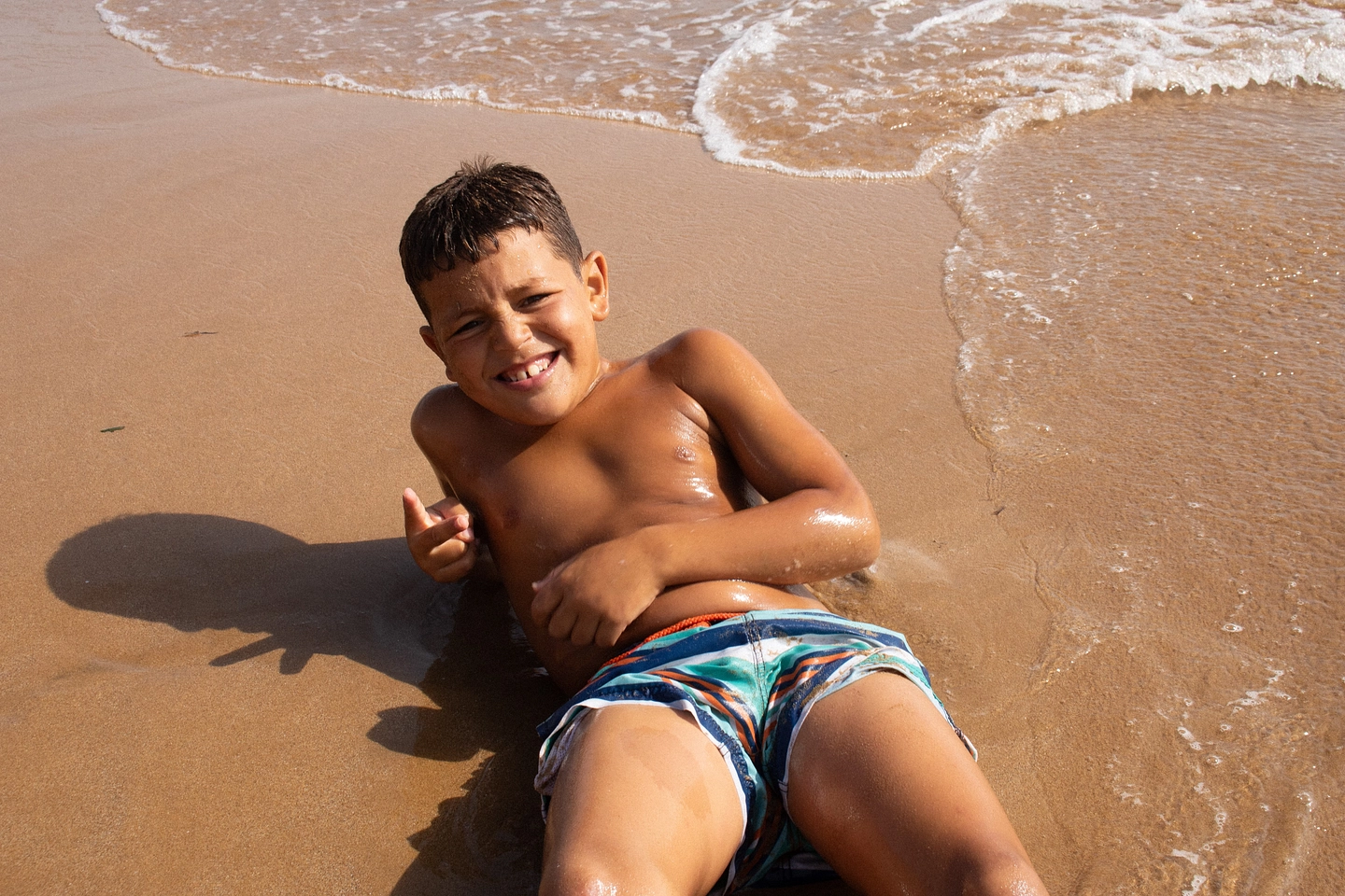 Still — boy lying in the surf